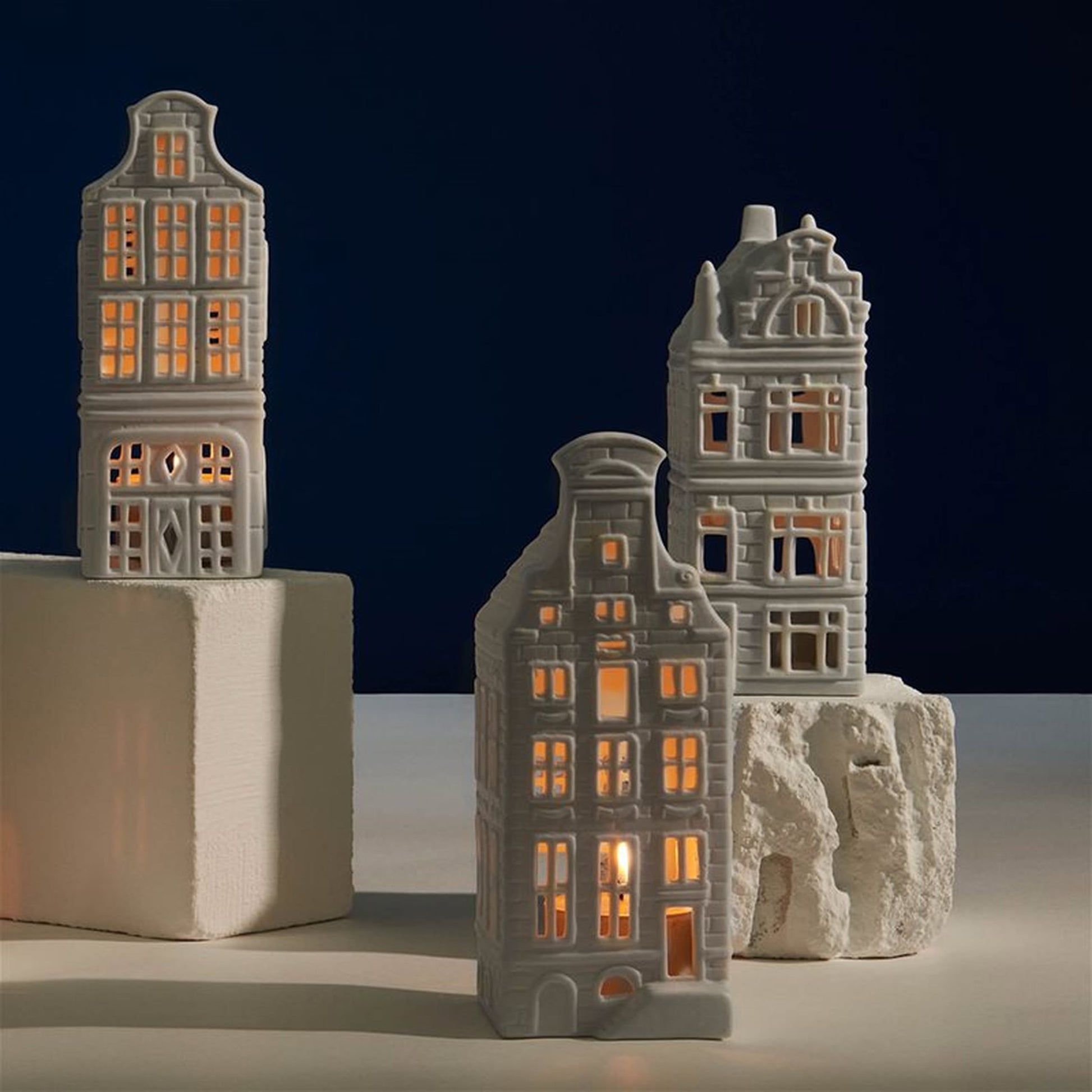 The &klevering Canal House #4 Tealight Set of 3 by &klevering features charming porcelain tealight holders that resemble glowing Amsterdam canal houses—an enchanting addition to your home décor.