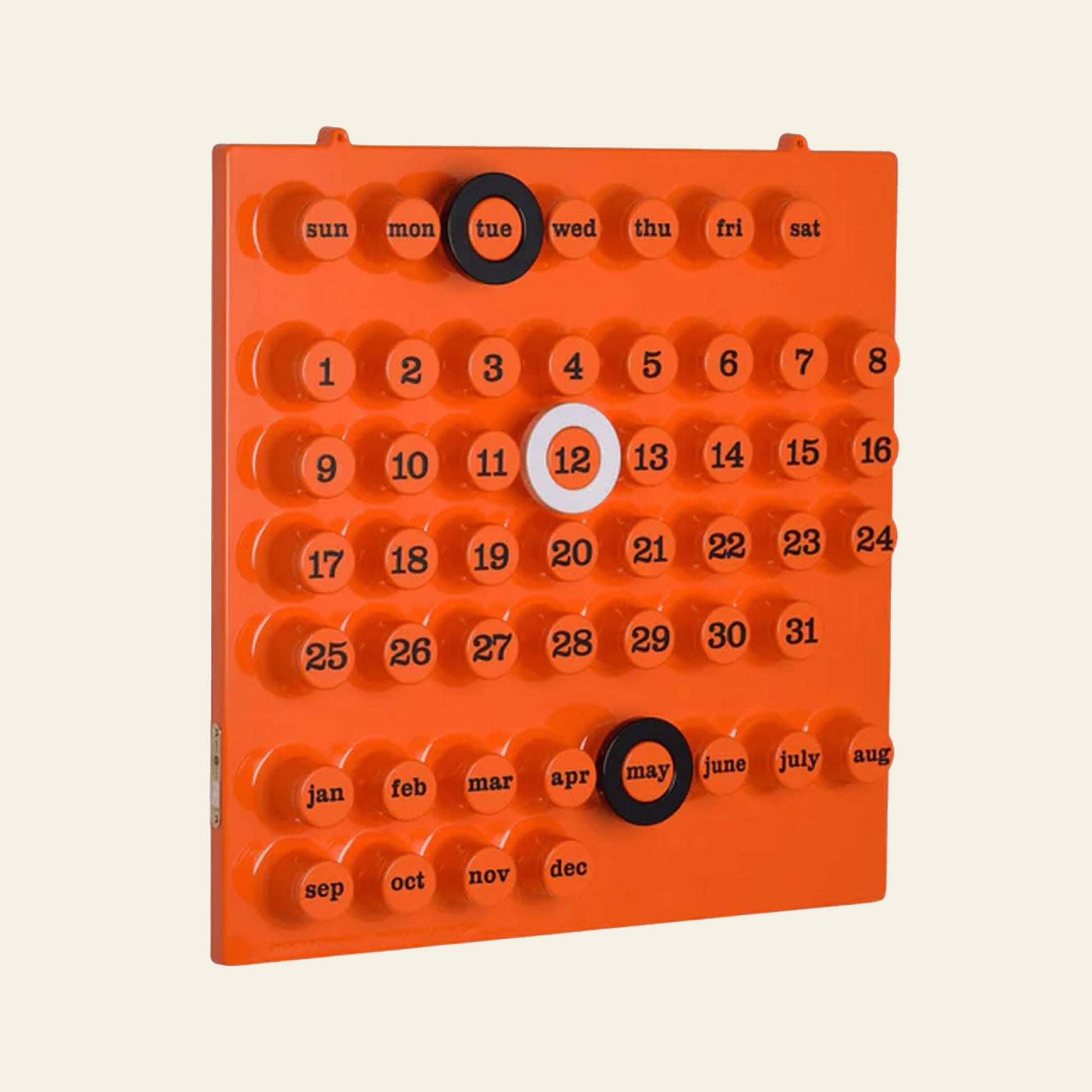 The Ring A Date Wall Calendar by Ring-A-Date is an orange retro calendar with movable circular markers. It stylishly displays Tuesday, May 12th, with days, dates, and months neatly arranged in rows.